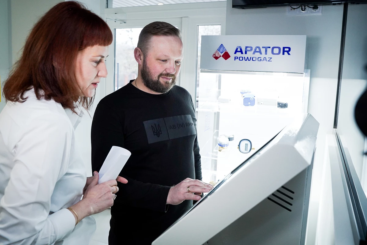 Two customers using the QSolutions QS19 self-service registration kiosk at the Poltavavodokanal Customer Service Center