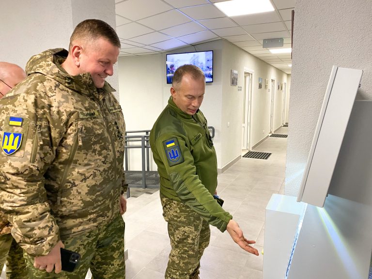 Military officers using a QSolutions self-service queue terminal at a Territorial Recruitment and Social Support Center