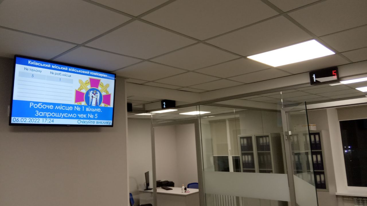 Officials reviewing the QSolutions self-service registration terminal