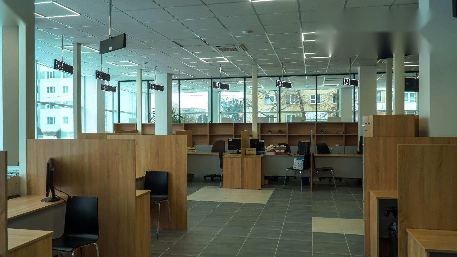 Front-office hall of the Drohobych Diia.Center with six visible RGB Matrix PRO LED counter indicators numbered 2 through 7 over operator desks