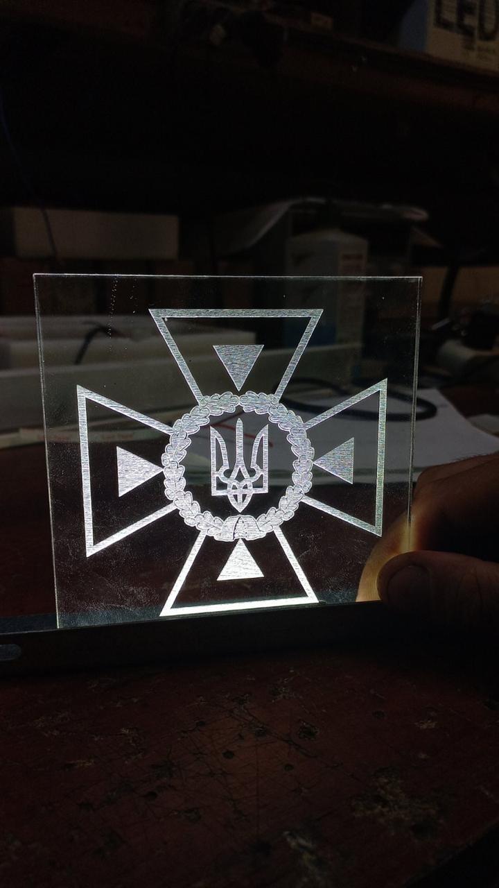 Engraved acrylic insert of the State Emergency Service emblem with edge-lit LED illumination, fitted into the QS55 kiosk lower body