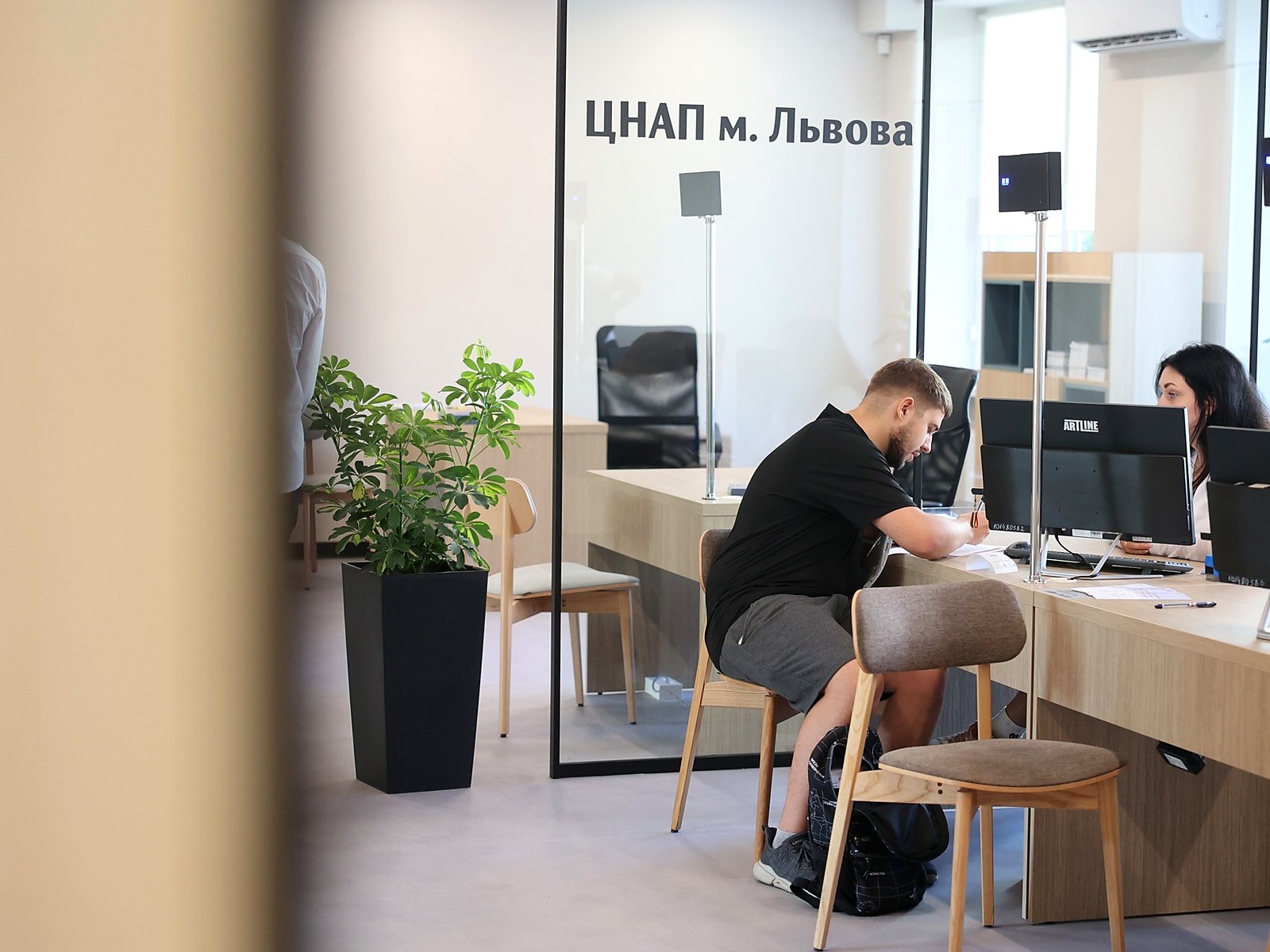 Operator working with a visitor at a counter equipped with QSolutions RGB Pro indicator