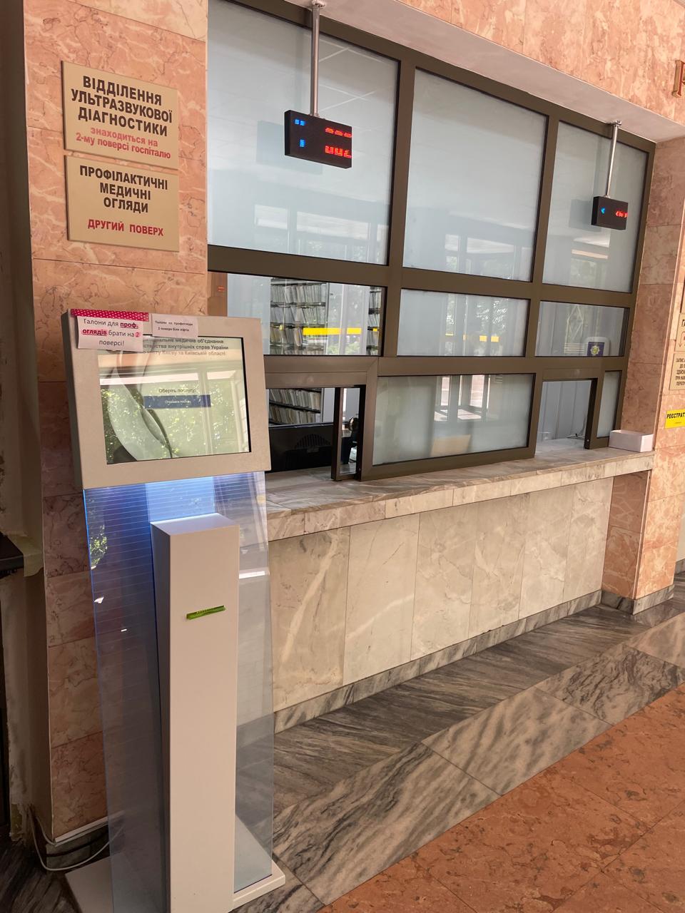 QSolutions self-service kiosk and LED counter display at the 2nd-floor service window