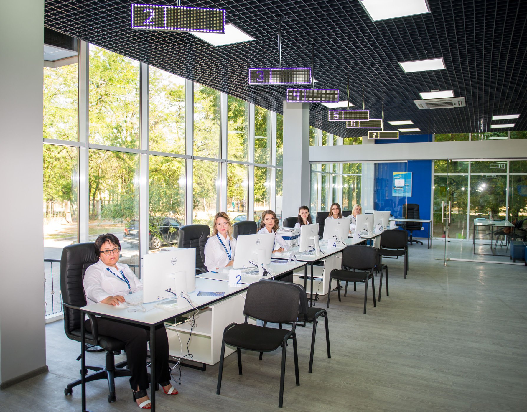 Morrichservice open service hall with operators serving seafarers under numbered LED matrix counter indicators