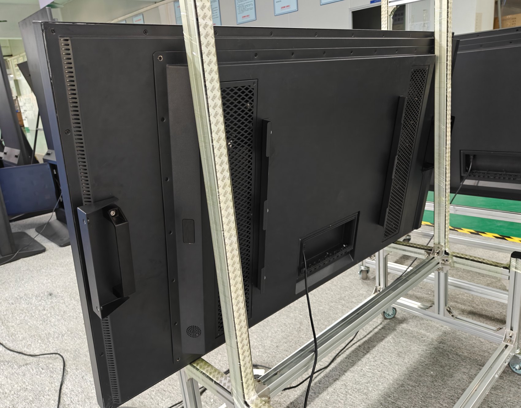 65″ Slim, rear panel at an angle: ventilation columns, handles, VESA